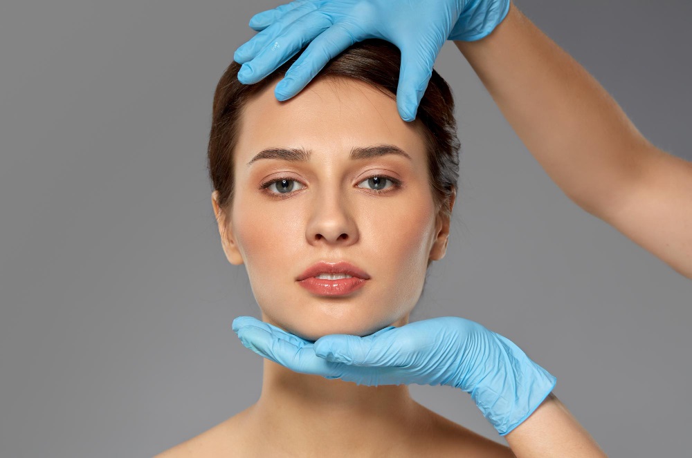 Doctor examining woman’s face after implants